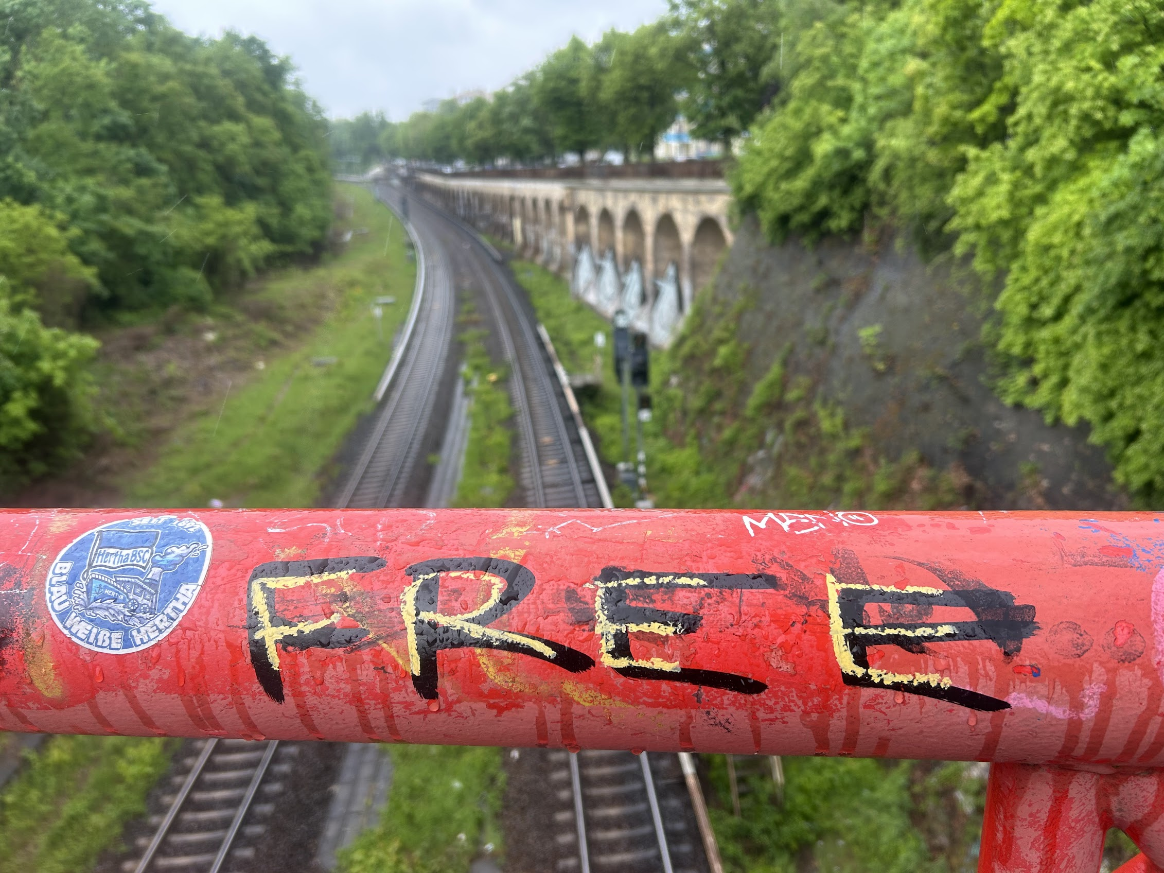 Räcke med graffitin FREE över tågspår i Berlin